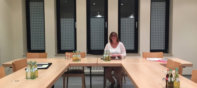 Veranstaltungsraum mit langem Tisch, Stühlen und Getränken