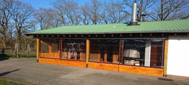 Grillhütte mit Holzfassade und sichtbarem Grill